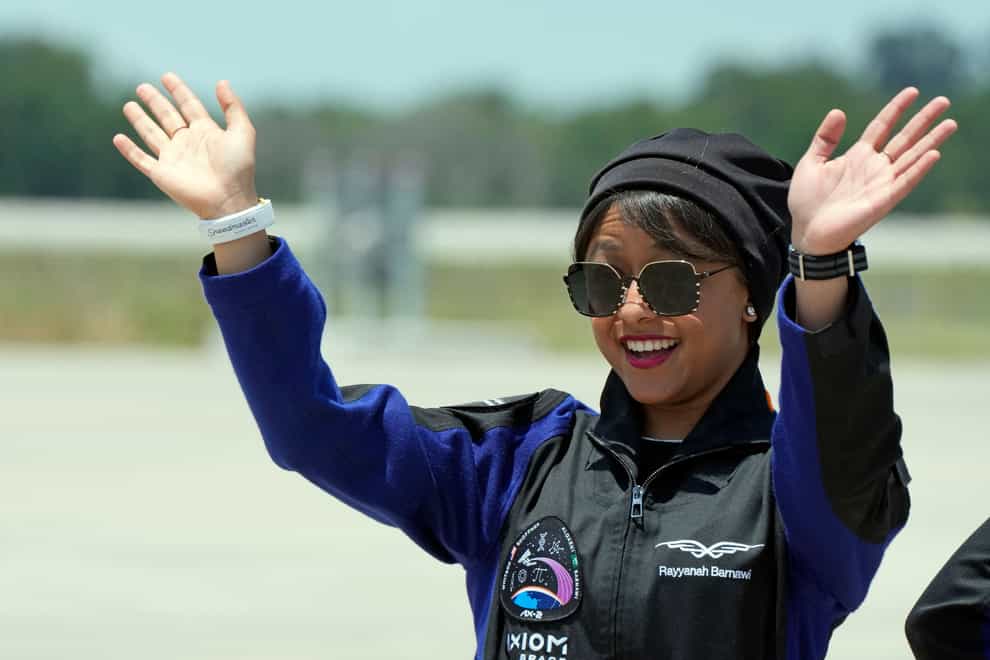 Saudi Arabian astronaut Rayyanah Barnawi waves to family and friends as she arrives at the Kennedy Space Centre in Cape Canaveral, Florida (John Raoux/AP)