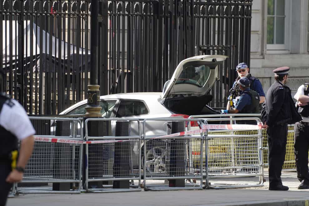 Police at the scene after a car collided with the gates of Downing Street in London. The Metropolitan Police said armed officers have arrested a man on suspicion of criminal damage and dangerous driving. Picture date: Thursday May 25, 2023.