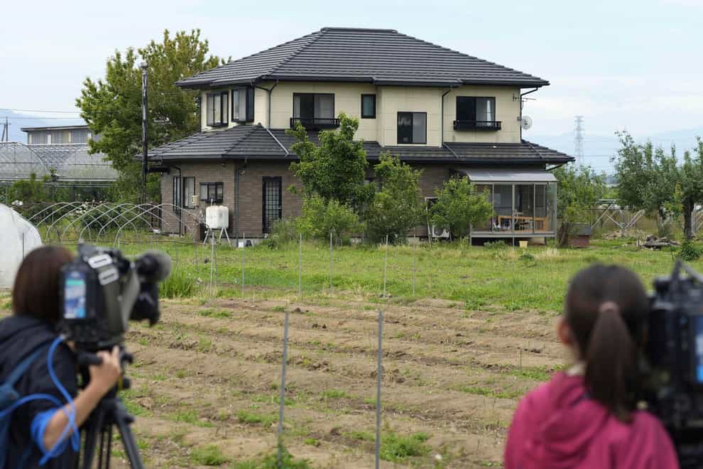 Journalists place cameras near a residential building where a man was holed up in Nagano (Kyodo via AP)