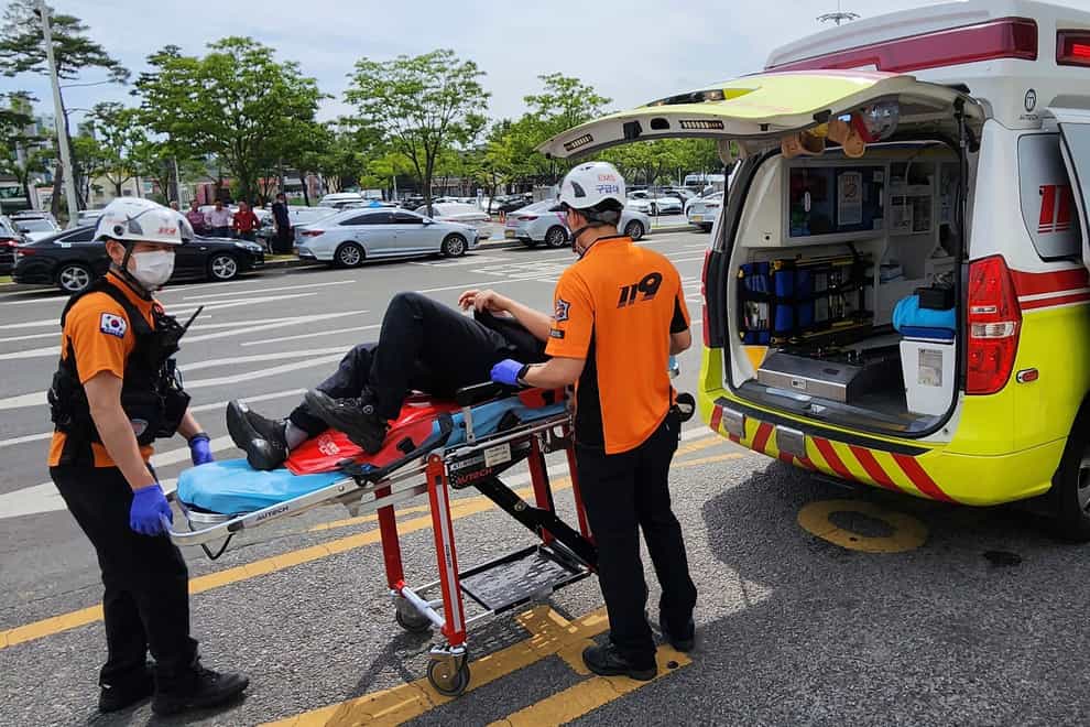 Rescue workers move a passenger on a stretcher to an ambulance at Daegu International Airport (Daegu Fire Station/Newsis via AP)