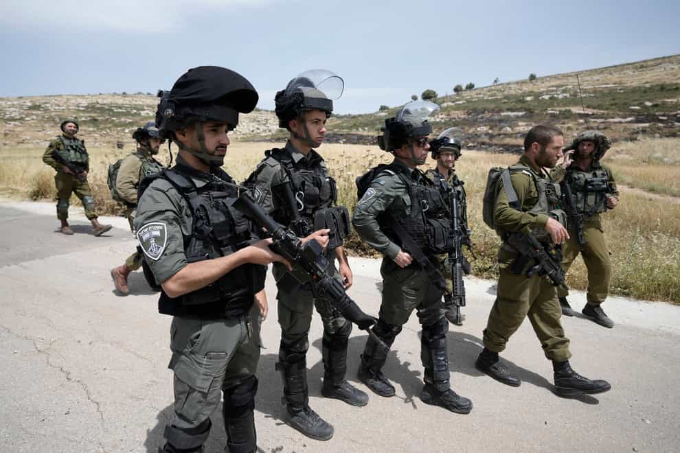 Israeli soldiers and border police deployed at the site where Israeli settlers burned Palestinian cars and wheat fields in the village of al-Mughayyir near the West Bank city of Ramallah on Friday, May 26, 2023 (Majdi Mohammed/AP/PA)