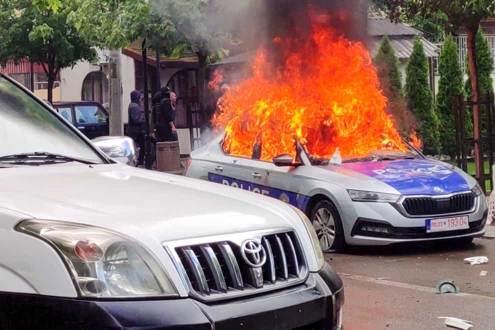 A police car burns in Zvecan, northern Kosovo (AP/PA)