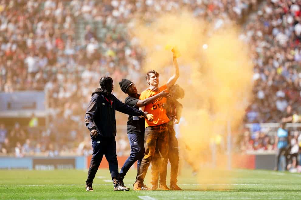 A Just Stop Oil protester is escorted off the pitch during the Gallagher Premiership final at Twickenham (David Davies/PA)