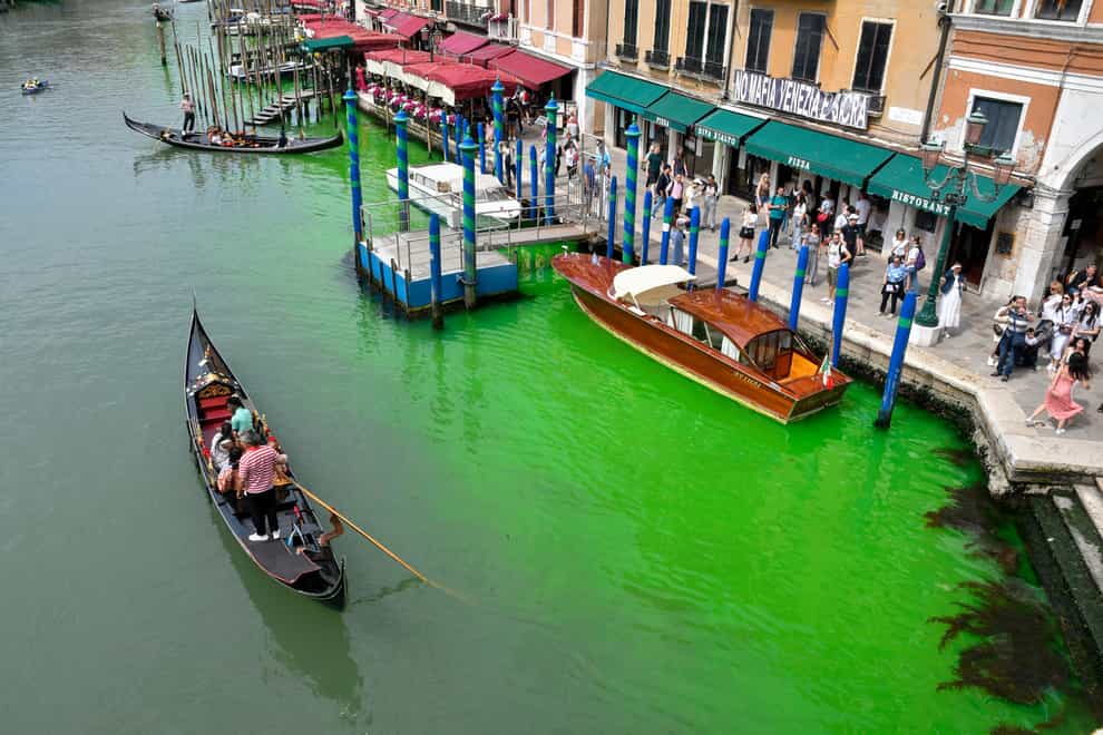 A gondola navigates along Venice’s historical Grand Canal as a patch of phosphorescent green liquid spreads in the water (Luigi Costantini/AP/PA)