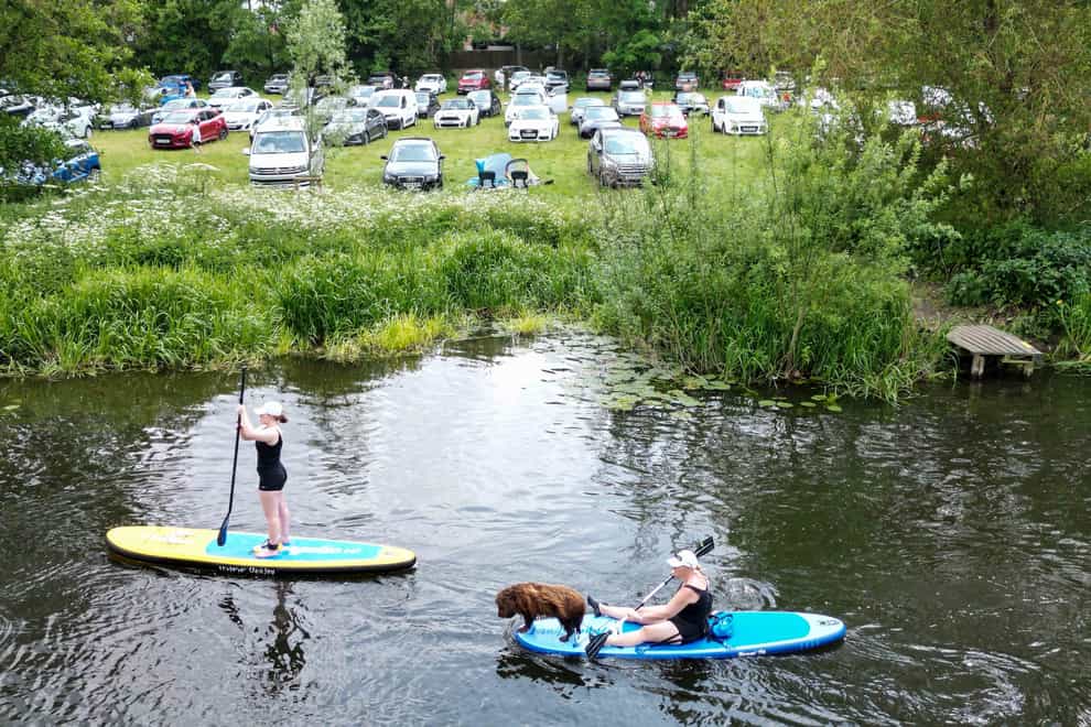 People enjoy the warm weather along the river Avon in Warwick (Jacob King/PA)