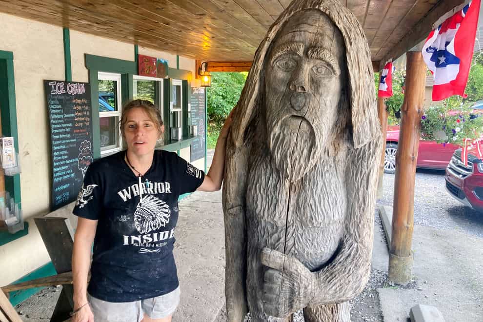 Pauline Bauer leans against a wooden statue outside Bob’s Trading Post, her restaurant in Hamilton, Pennsylvania (Michael Kunzelman/AP/PA)