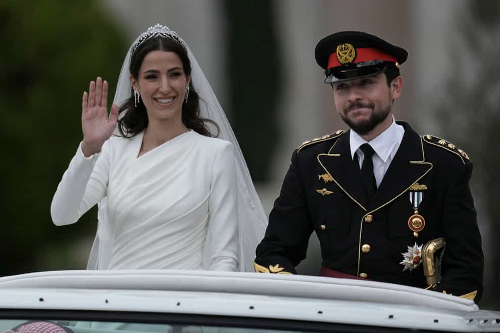 Jordan’s Crown Prince Hussein and Rajwa Alseif wave to well-wishers (Nasser Nasser/AP)