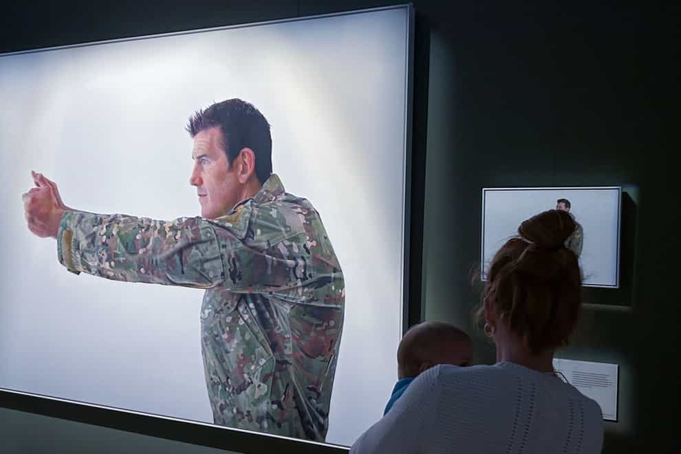 A visitor looks at a display featuring decorated war veteran Ben Roberts-Smith at the Australian War Memorial in Canberra, Australia (Rod McGuirk/AP)