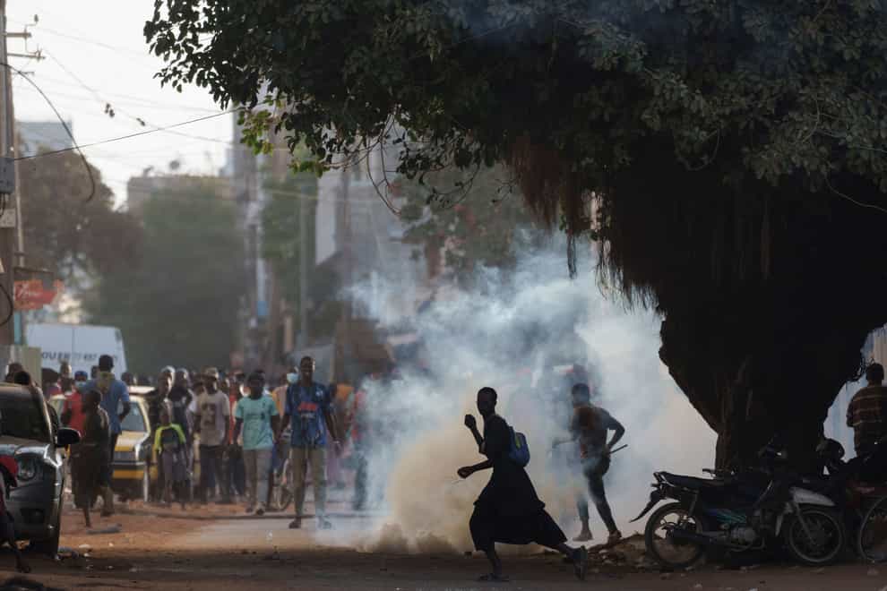 Demonstrators run after police fire tear gas during a protest at a neighbourhood in Dakar, Senegal (Leo Correa/AP/PA)