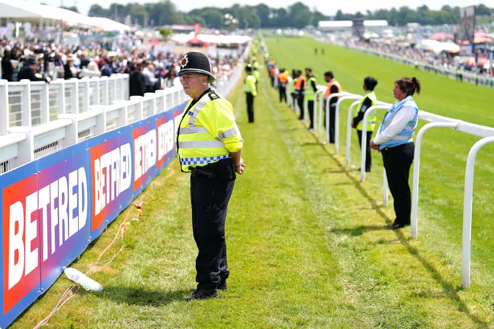 Police officer stands by the track during Derby Day of the 2023 Derby Festival at Epsom Downs Racecourse, Epsom. Picture date: Saturday June 3, 2023.