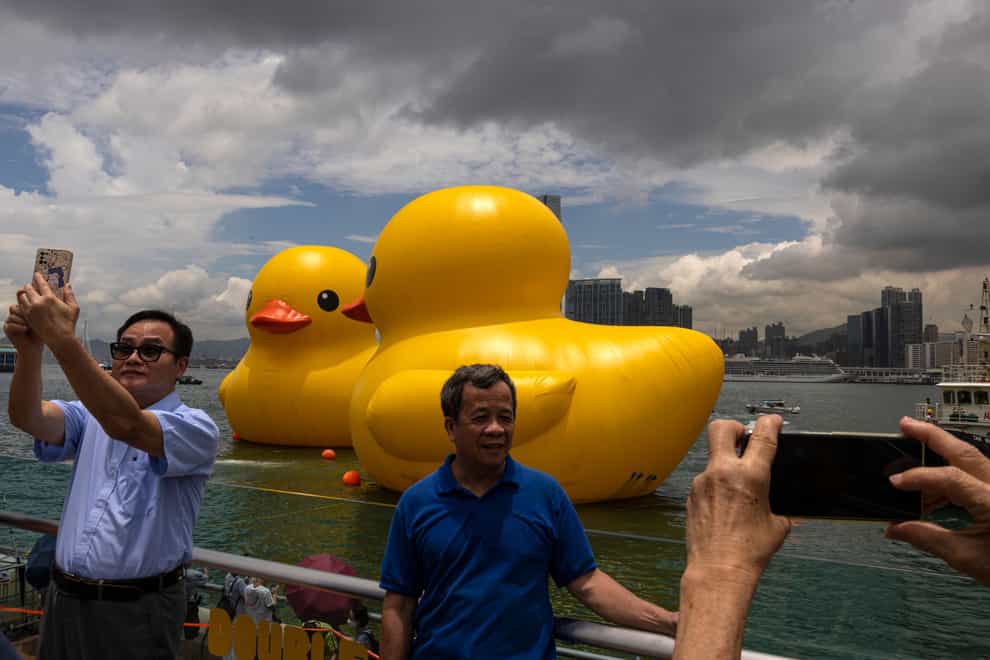 People take pictures of an art installation called Double Ducks (Louise Delmotte/AP)