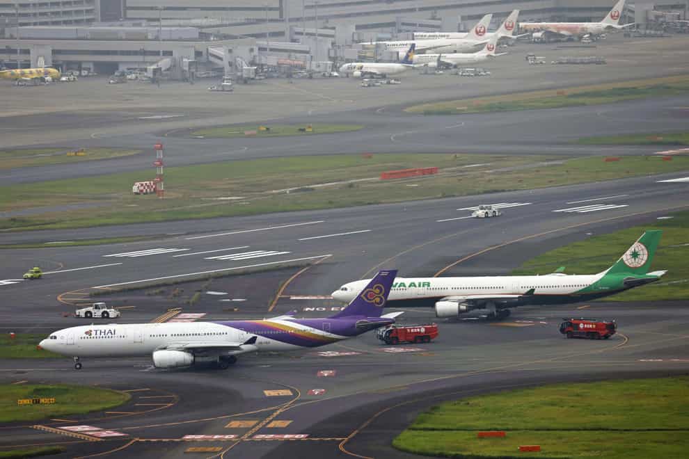 The two planes sit close on a runway after the two passenger planes accidentally hit each other at Haneda airport (Kyodo News via AP)
