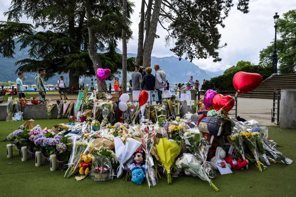 Flowers, balloons and toys have been left at the scene of the attack in Annecy, France (Jean-Christophe Bott/Keystone/AP)