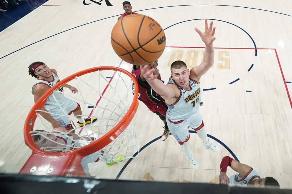 Denver Nuggets center Nikola Jokic, center right, and Miami Heat center Bam Adebayo, center left, compete for a rebound during the second half of Game 2 of basketball’s NBA Finals, Monday, June 12, 2023, in Denver. (AP Photo/Jack Dempsey, Pool)
