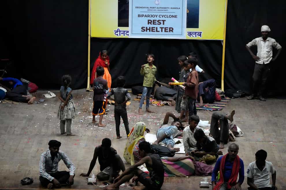 People evacuated from Kandla port, in preparation for Cyclone Biparjoy, rest at a shelter in Gandhidham, India (Ajit Solanki/AP)