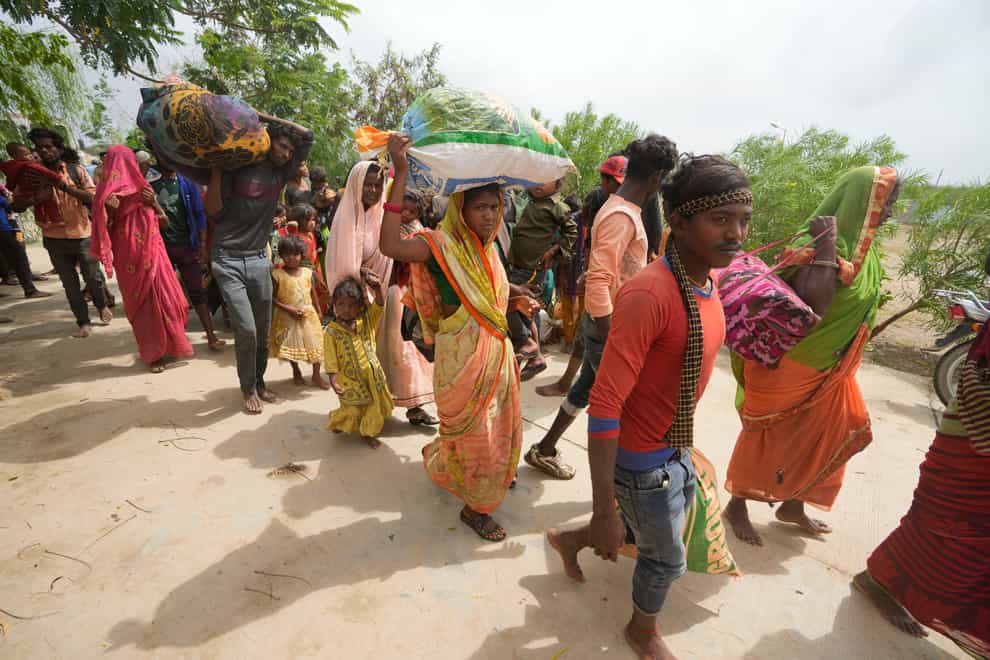 People evacuated from a village near Jakhau arrive at a shelter in Naliya, Kutch district, India, on Wednesday, June 14, 2023 (Ajit Solanki/AP/PA)