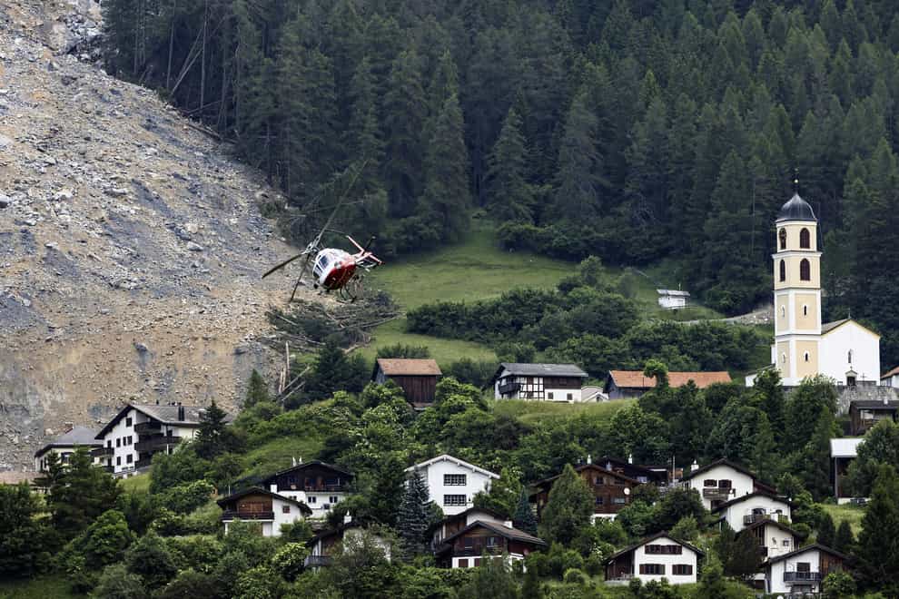 A helicopter flies over the rockfall above the village of Brienz in Switzerland (Michael Buholzer/Keystone via AP)