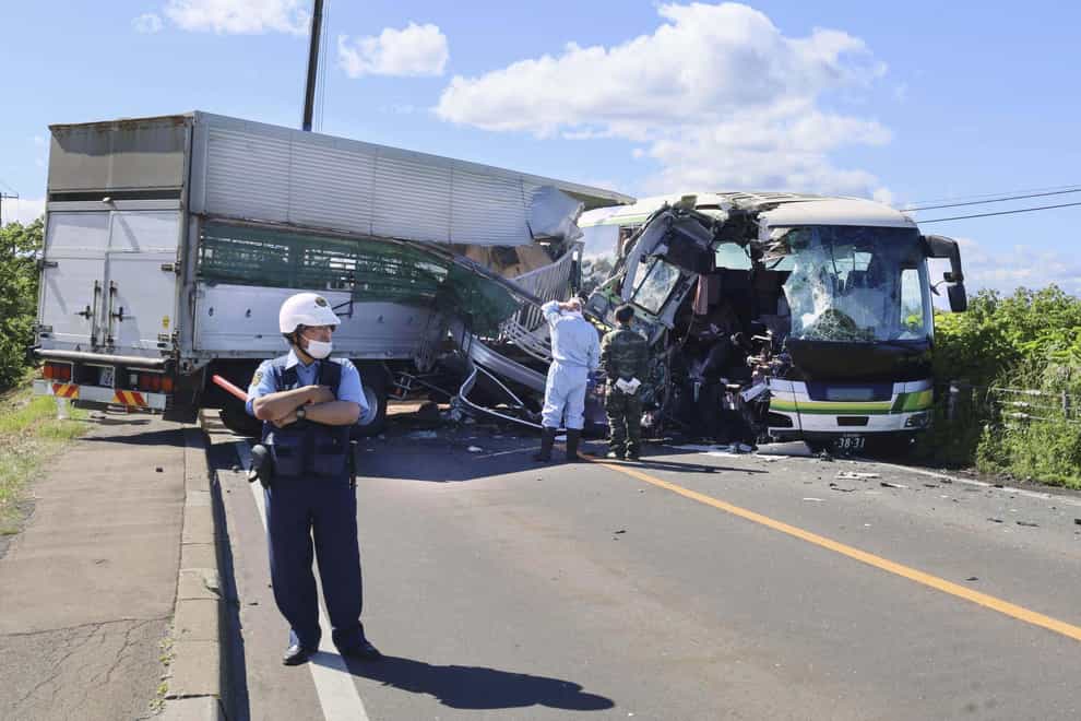 Police at the scene of a crash between a bus and a truck in Yakumo, Hokkaido prefecture (Kyodo News via AP)