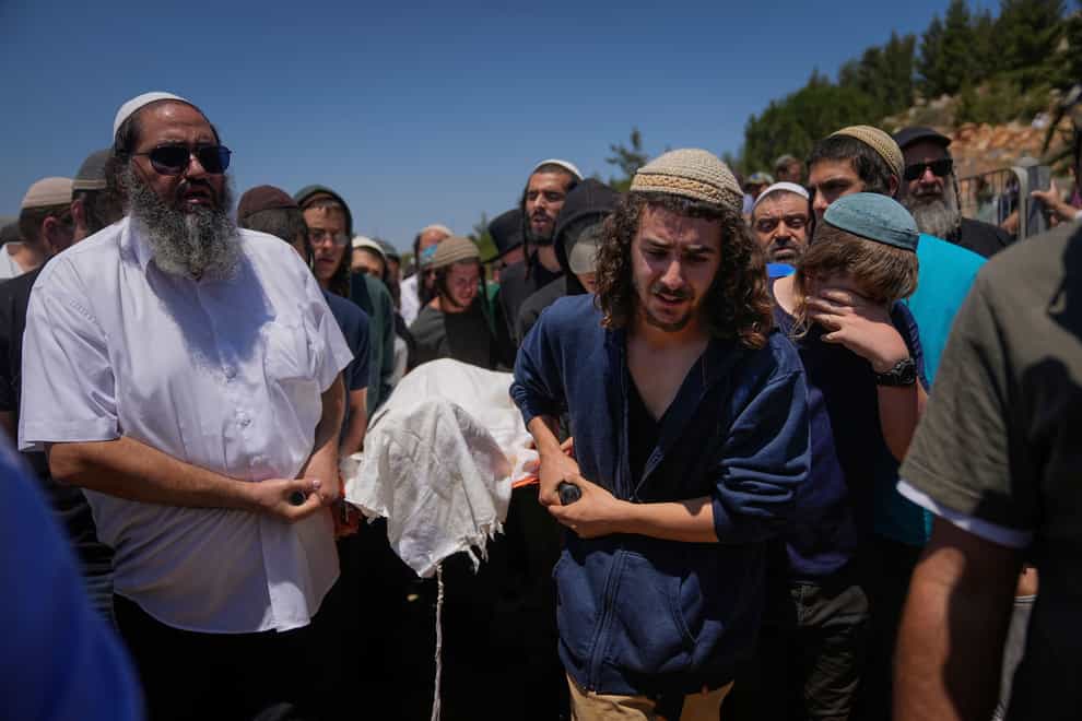 Mourners carry the body of Nahman Mordoff, 17, during his funeral in the West Bank Israeli settlement of Shilo after his death in the shooting (AP)