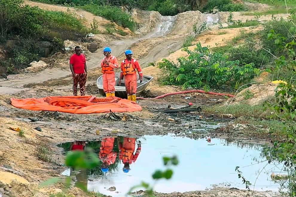 Workers collect oil spill waste in Ogoniland (AP)