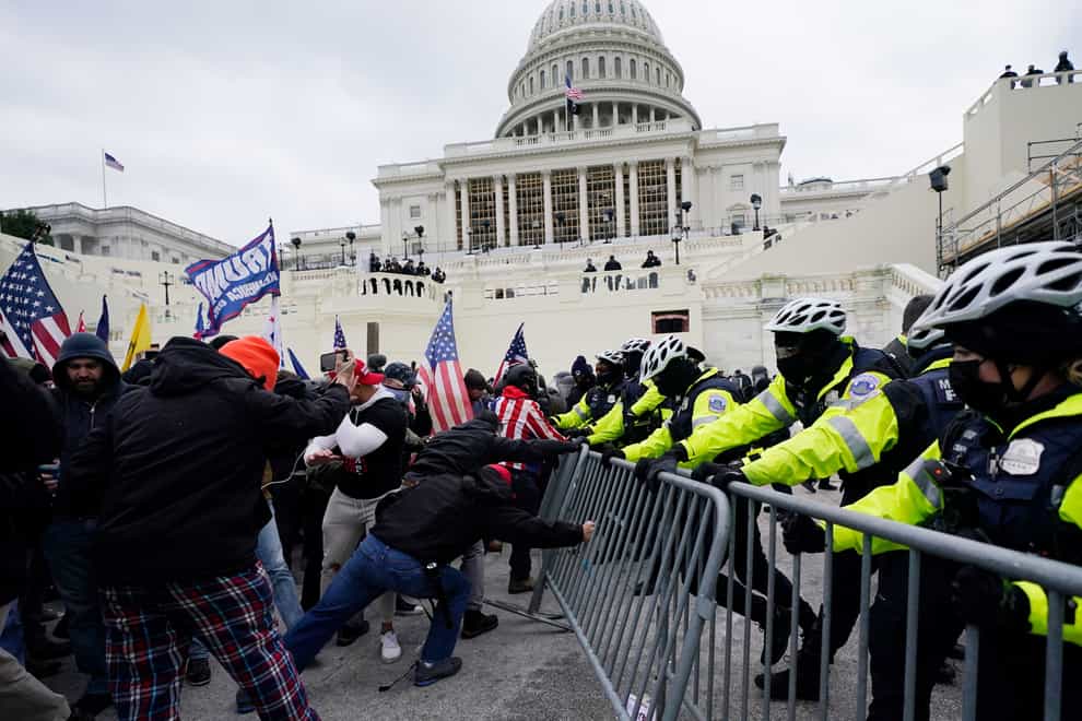 Rioters supporting then president Donald Trump try to break through a police barrier at the Capitol in Washington, on January 6 2021 (Julio Cortez/AP)