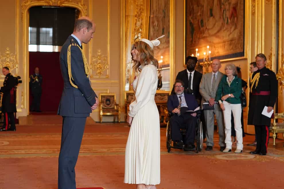 Kate Garraway was made an MBE by the Prince of Wales at Windsor Castle, as her husband, Derek Draper, watched from a wheelchair nearby (Jonathan Brady/PA)