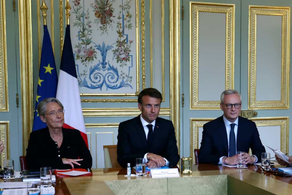 French President Emmanuel Macron, centre, French Prime Minister Elisabeth Borne, left, and Economy Minister Bruno Le Maire attend a government emergency meeting (Mohamed Badra/AP)