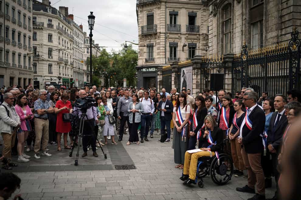 People gather in front of the city hall in Lyon, central France, in a show of solidarity with the mayor of the Paris suburb of L’Hay-les-Roses after a burning car struck his home (Laurent Cipriani/AP)