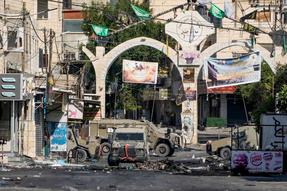 Army vehicles are seen during an Israeli military raid on the militant stronghold of the Jenin refugee camp in the occupied West Bank (Majdi Mohammed/AP)