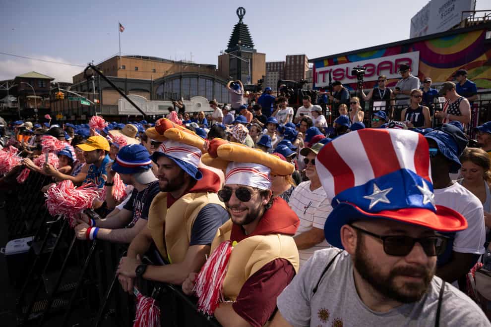 People gather ahead of the 2023 Nathan’s Famous Fourth of July hot dog eating contest in the Coney Island section of Brooklyn, New York on Tuesday, July 4, 2023 (Yuki Iwamura/AP/PA)