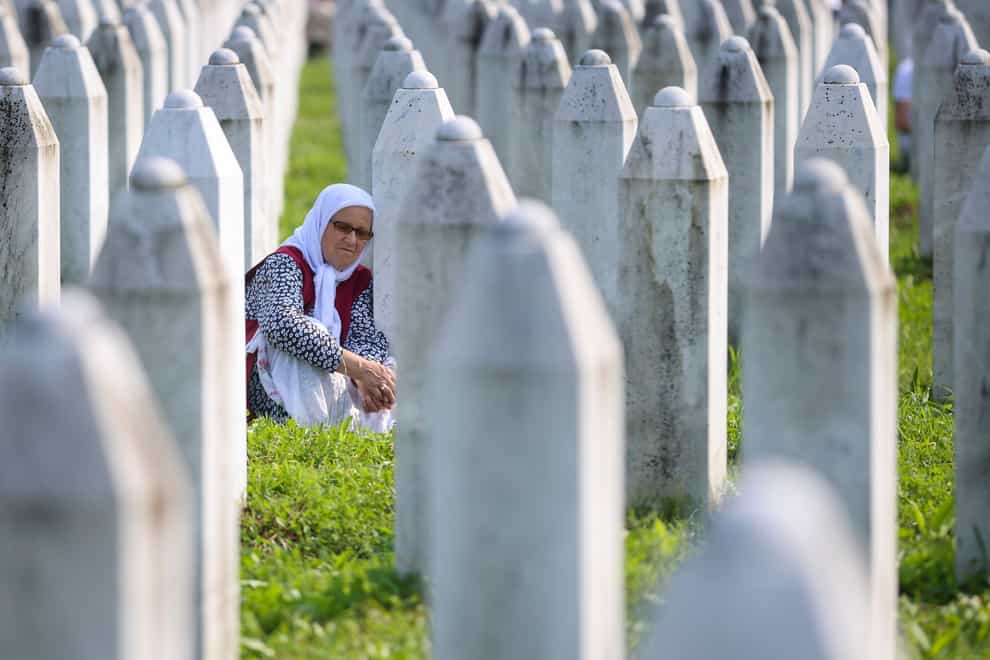 A Bosnian woman mourns next to the grave of her relative (Armin Durgut/AP)