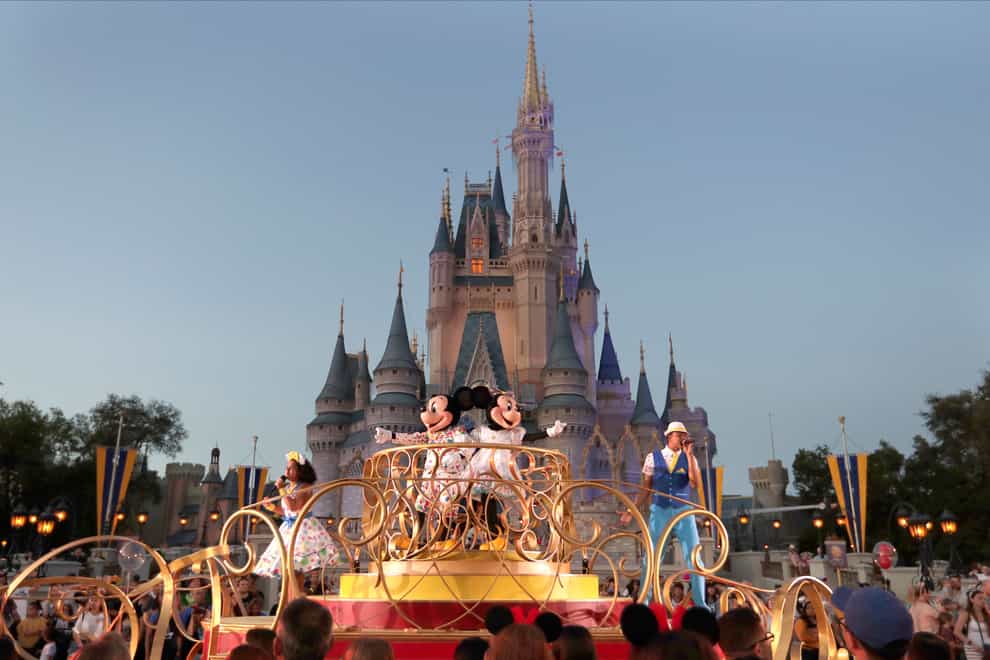 Mickey and Minnie Mouse perform during a parade as they pass by the Cinderella Castle at the Magic Kingdom theme park at Walt Disney World in Lake Buena Vista, Florida (John Raoux/AP)