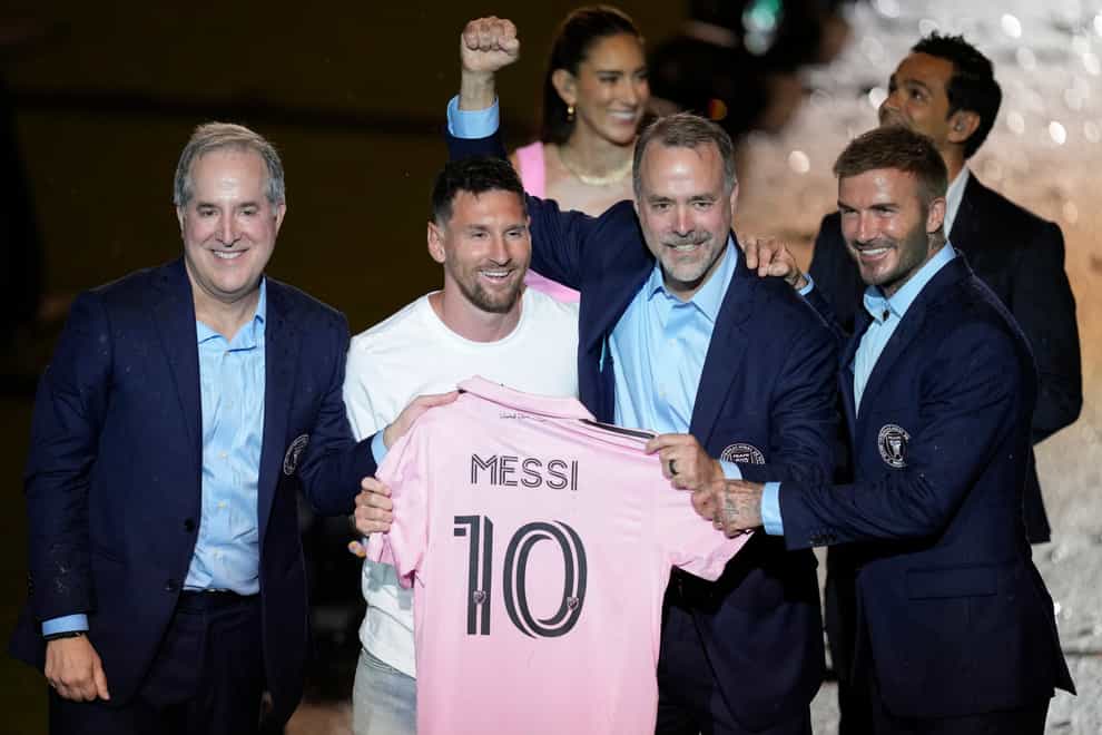 Inter Miami’s Lionel Messi, centre left, holds his new Inter Miami team jersey as he poses with team co-owners Jorge Mas, left, Jose Mas, second right, and David Beckham during a celebration by the team at DRV PNK Stadium in Fort Lauderdale, Florida (Rebecca Blackwell/AP)