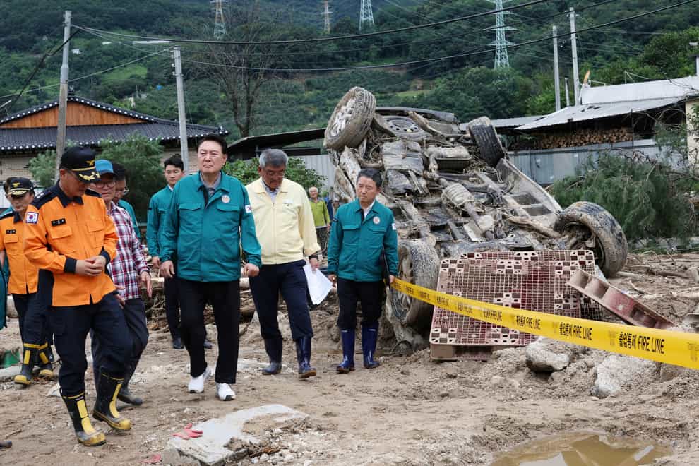 South Korean President Yoon Suk Yeol, fourth from left, looks around a flood damaged area in Yecheon, South Korea (Jin Sung-chul/Yonhap via AP)