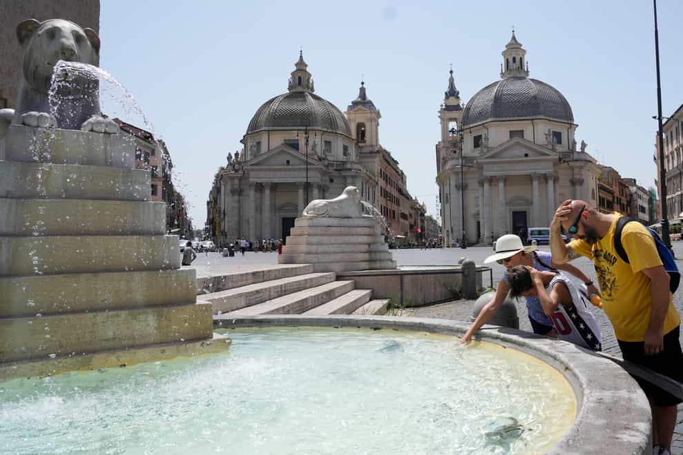 Tourists cool off at the Lions fountain in Rome (Gregorio Borgia/AP)