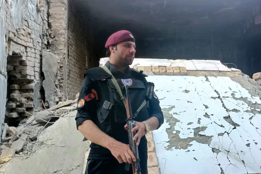 A security member stands guard inside a damaged police compound after a suicide bomber attack in the Bara Khyber Pakhtunkhwa, Pakistan (Qazi Rauf/AP/PA)