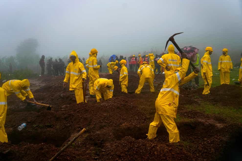 Rescuers dig graves to bury the bodies of victims at the site of a landslide in the Raigad district, western Maharashtra state, India (Rafiq Maqbool/AP/PA)