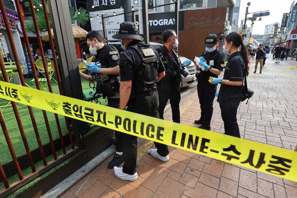 Police officers investigate the scene of a stabbing (Yonhap via AP)