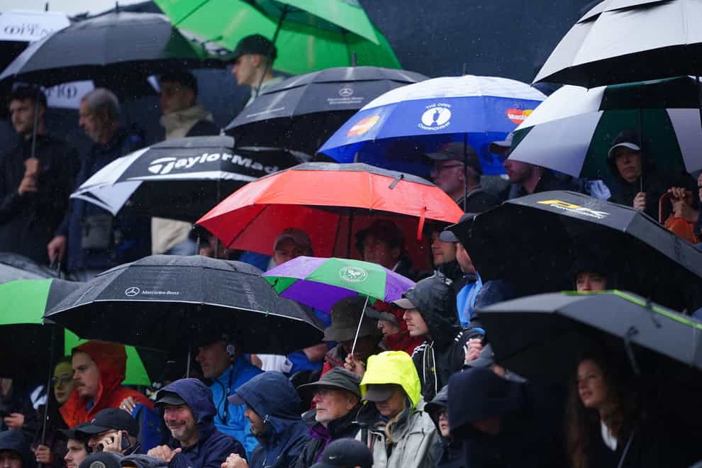 Spectators shelter under umbrellas during day three of The Open at Royal Liverpool (Peter Byrne/PA)