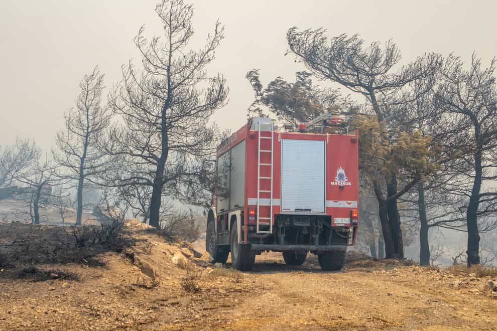 A firefighting vehicle makes its way through burnt trees during a forest fire on the island of Rhodes (Lefteris Diamanidis/InTime News/AP)