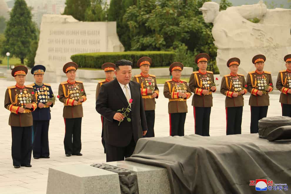 North Korean leader Kim Jong Un, foreground, prepares to offer a flower at a liberation war martyrs cemetery in Pyongyang, North Korea (Korean Central News Agency/Korea News Service via AP)