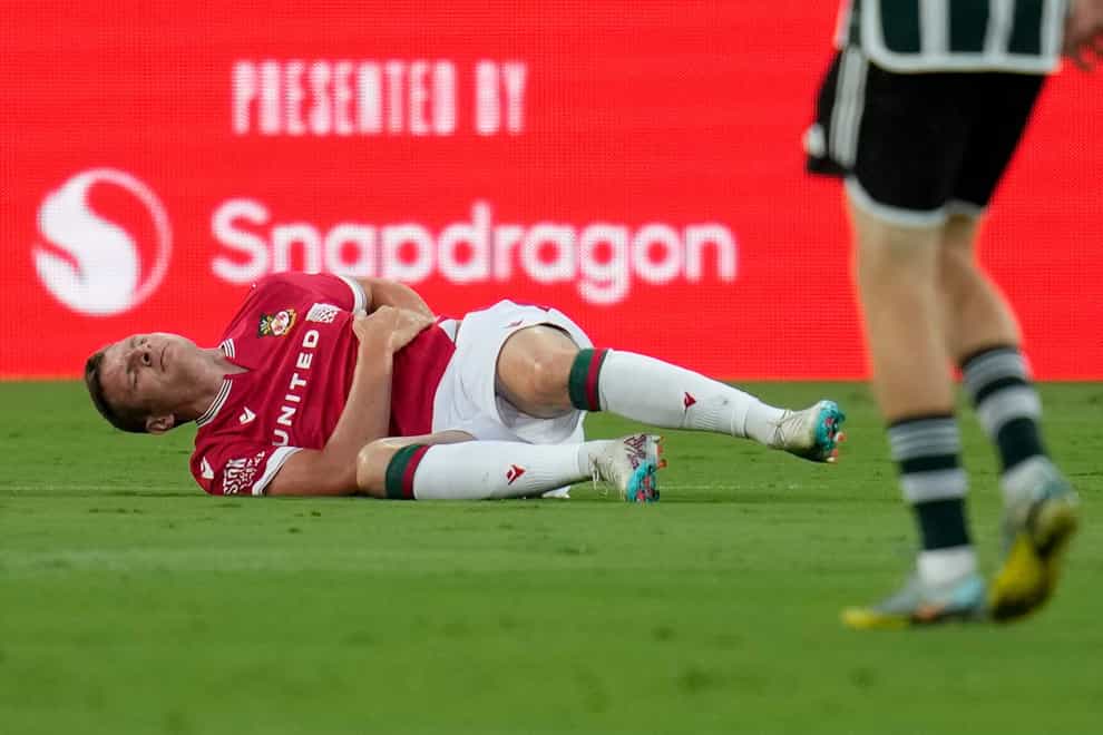 Wrexham forward Paul Mullin stays on the field after an injury during the first half of a club friendly soccer match against Manchester United in San Diego (Gregory Bull, AP)