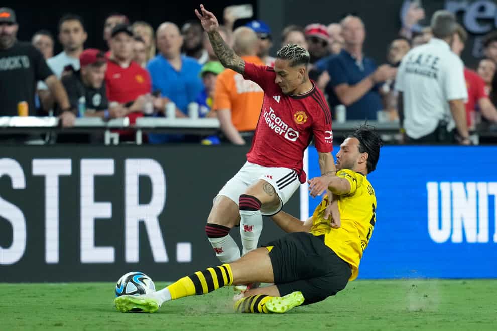Borussia Dortmund’s Ramy Bensebaini tackles Manchester United’s Antony (John Locher/AP)