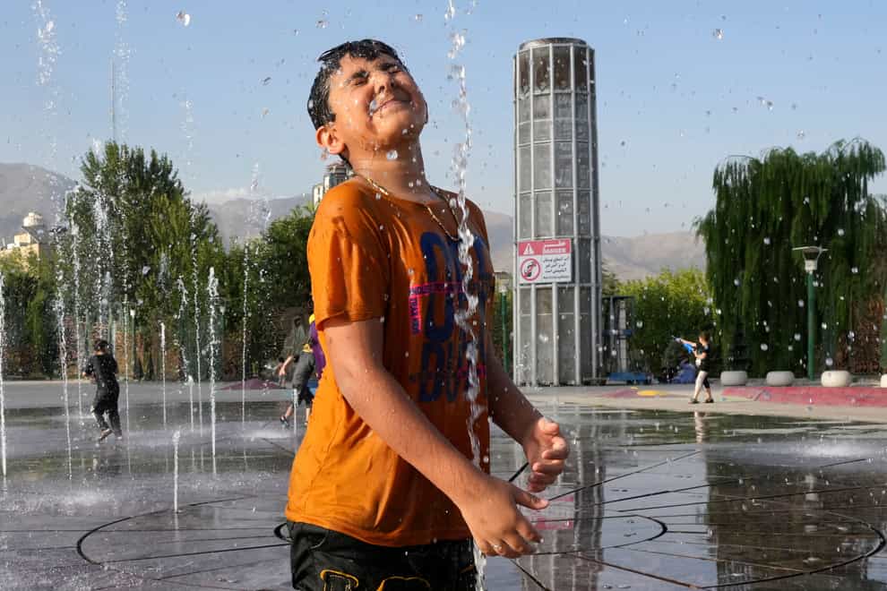 A boy cools off in a water fountain at the Ebrahim Park in Tehran as the temperature reached 38C (Vahid Salemi/AP/PA)