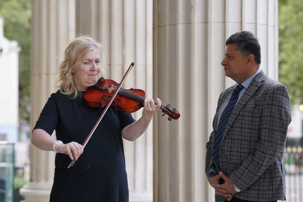 Dagmar Turner, who played the violin while surgeons removed a tumour from her brain, has been reunited with consultant neurosurgeon Professor Keyoumars Ashkan after two-and-a-half years (Lucy North/PA)