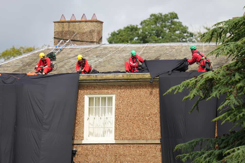 Greenpeace activists moving fabric on the roof (Danny Lawson/PA)