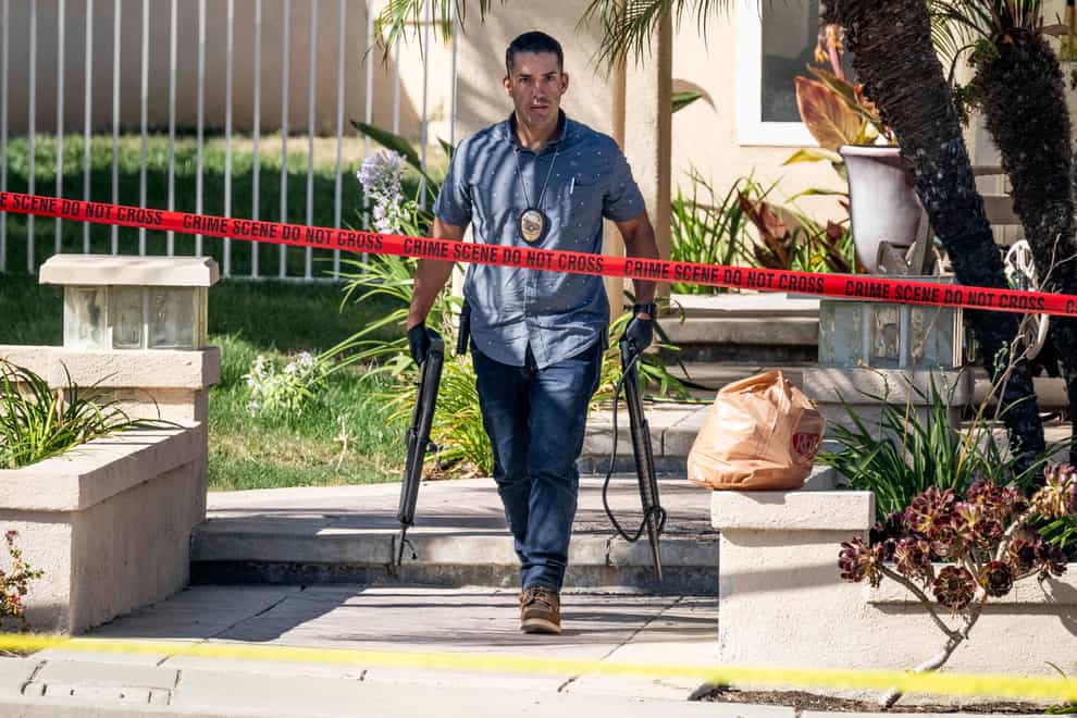 Investigators remove firearms from a house in Anaheim (Paul Bersebach/The Orange County Register via AP)