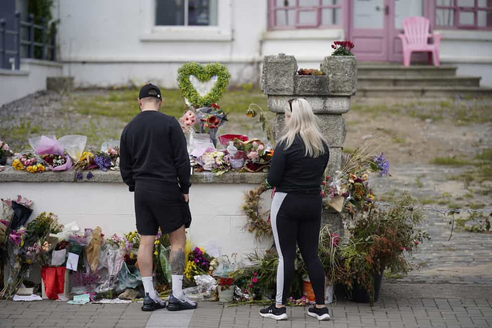 People look at flowers outside Sinead O’Connor’s former home in Bray, Co Wicklow, ahead of the 56-year-old’s funeral on Tuesday. The Irish singer was found “unresponsive” at her home in Lambeth, south London last month. (Niall Carson/PA)