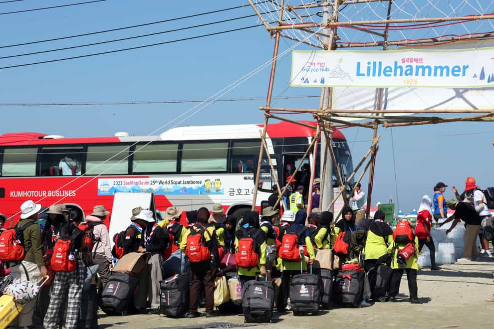 Attendees of the World Scout Jamboree get on a bus to leave a campsite in Buan (Na Bo-bae/Yonhap via AP)