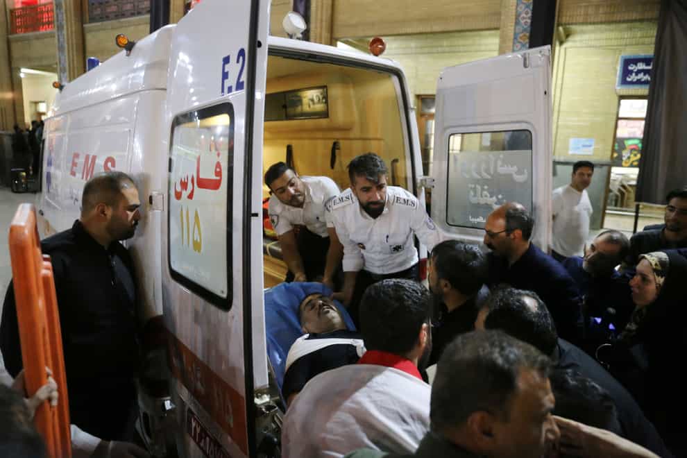 Medics carry a wounded man into an ambulance (Reza Ghaderi, IRNA via AP)